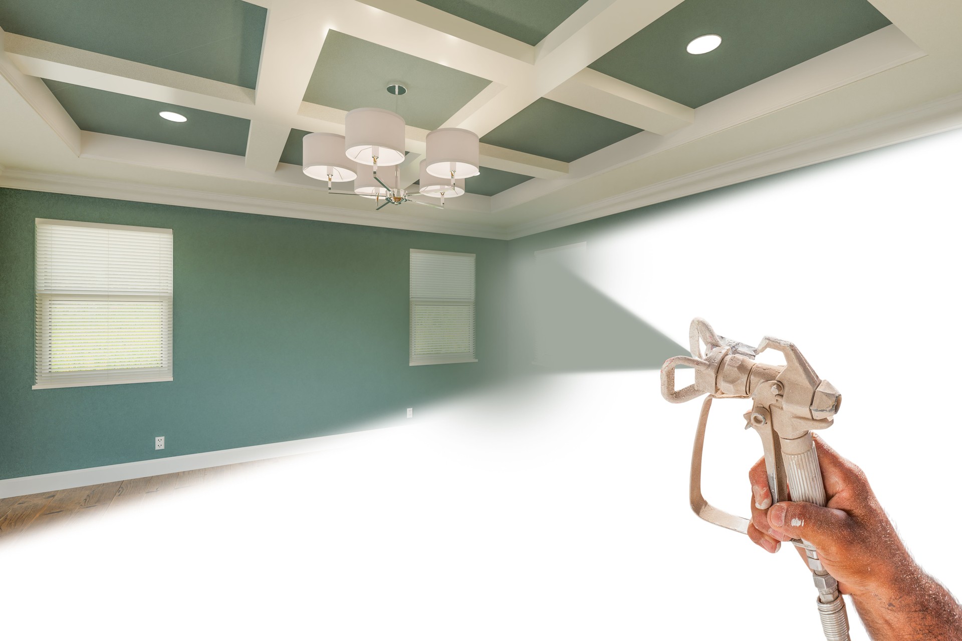Professional Spray Painter Holding Spray Gun Spraying Renovated Room Over White Surface.