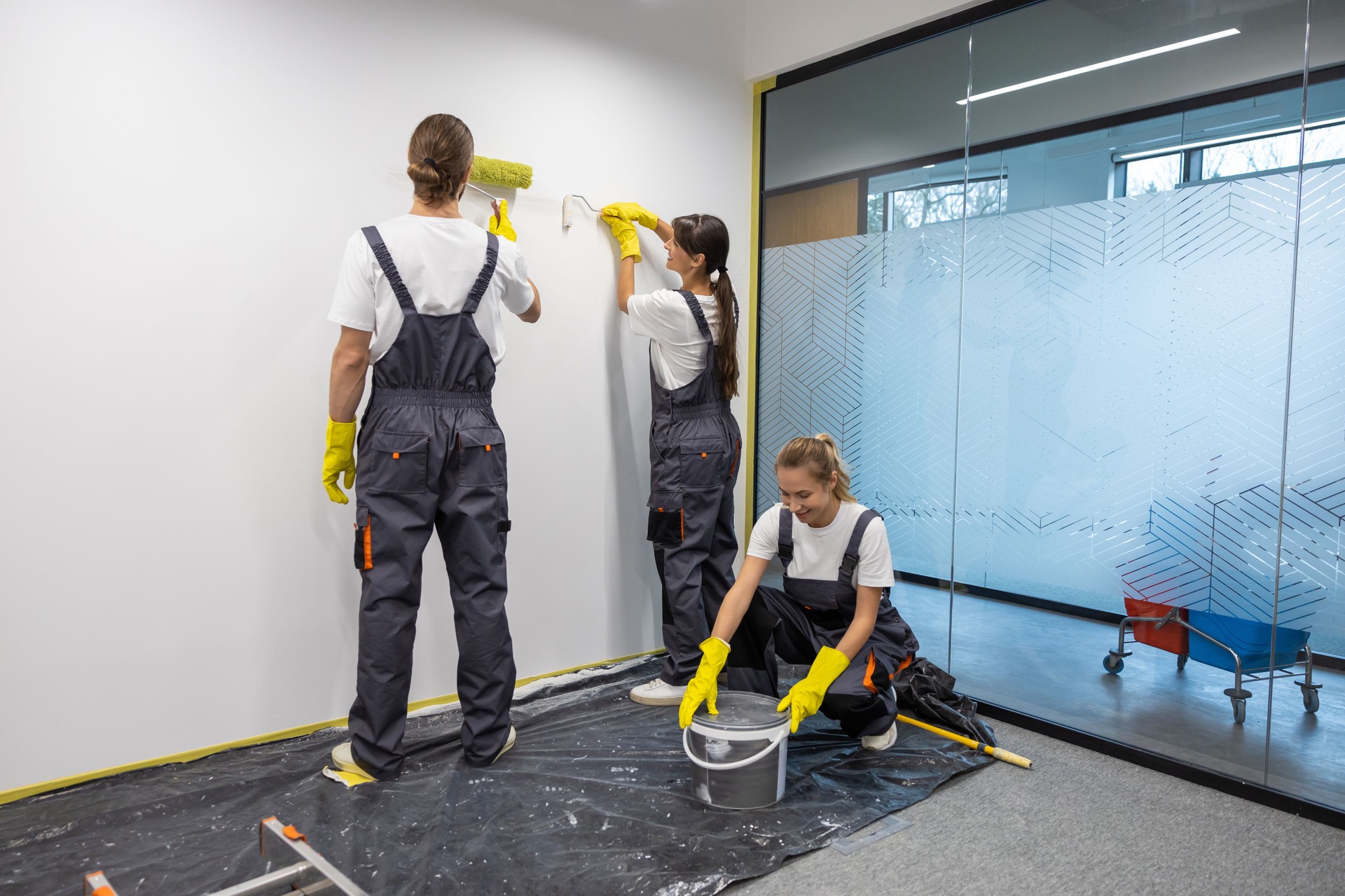 Group of housekeeping staff painting the walls in the office